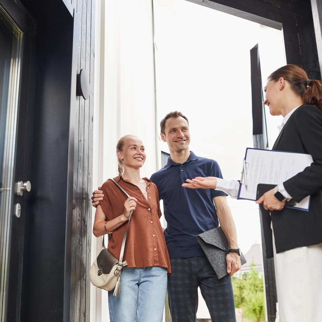 Real estate agent showing home to couple.